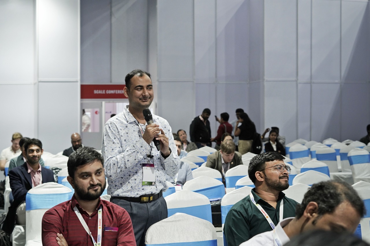 An attendee stands with a microphone to ask a question at the SCALE conference.